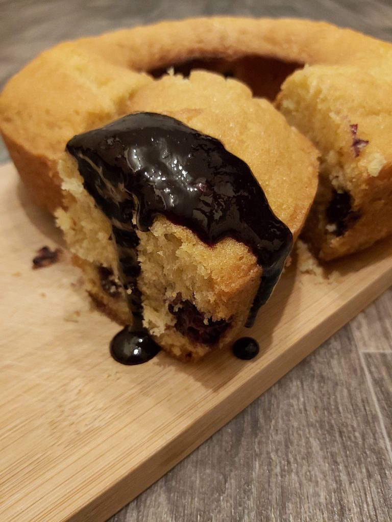 Sponge cake with blackberry coulis dripping down the sides