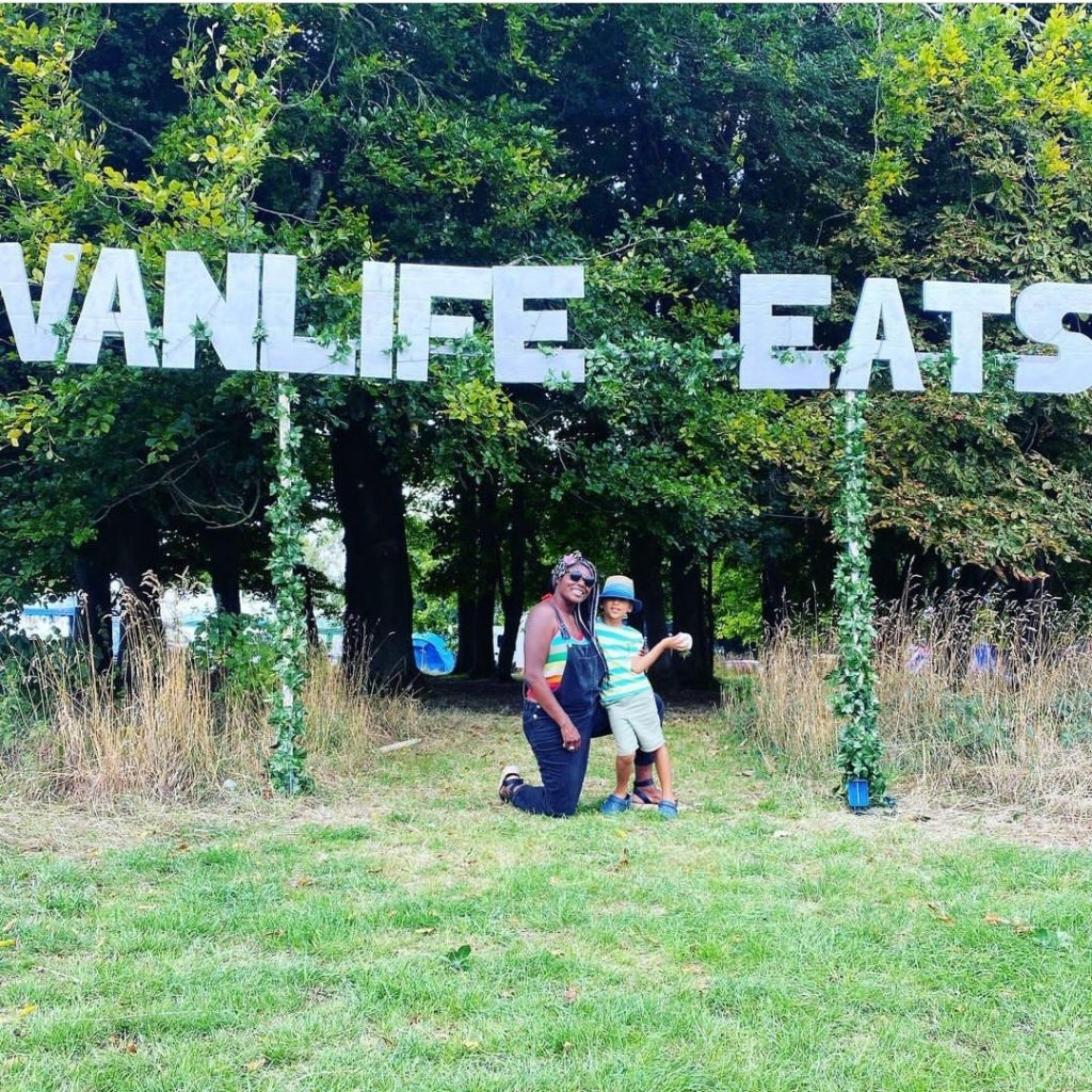 Delaine and Quincy in front of the Vanlife Eats sign at the Vanlife Eats festival